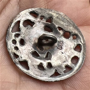 Hallmarked silver button of two men drinking.
