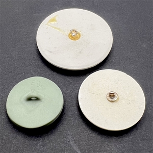 Three assorted ceramic buttons of U.S. presidents.