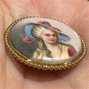 Porcelain button of women in blue and pink hat.