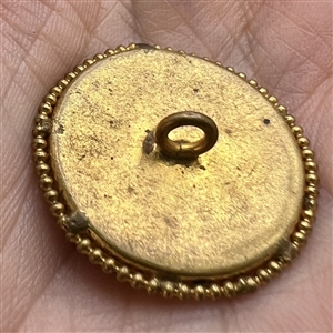 Porcelain button of women in blue and pink hat.