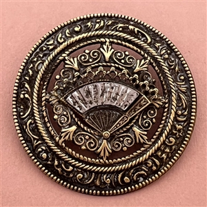 Ornate brass open work button with steel fan.