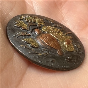 Japanese Shakudo button of bird and butterfly among flowers.