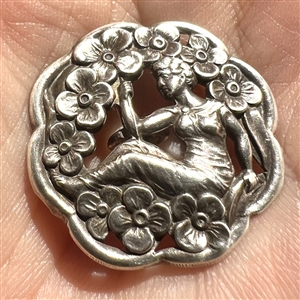 Hallmarked silver button of woman among flowers.