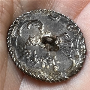 Hallmarked silver button of a musician playing.