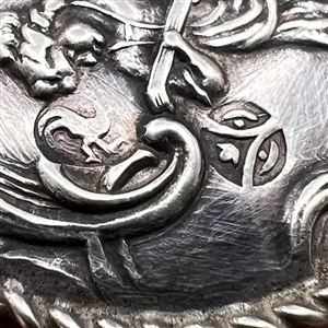 Hallmarked silver button of a musician playing.