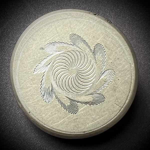 An 18th c. Tombac button with central spiral design.