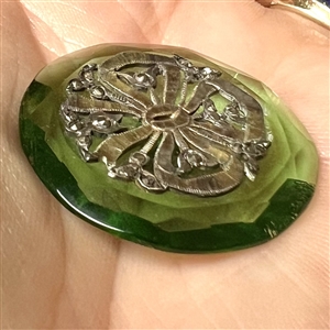 Transparent green glass button with bow.
