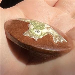 Natural material set in boxwood button of a frog.