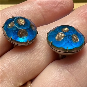 Two buttons of faceted aqua glass with goldstone.