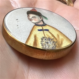 Painting on fabric button of an Asian man.