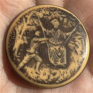 Large ivoroid “tight top” button of a man pushing a woman on a swing.
