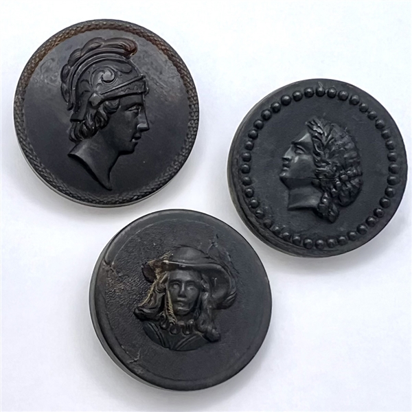 Three molded horn buttons of heads.