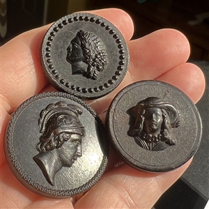 Three molded horn buttons of heads.