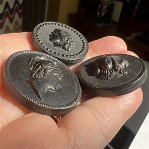 Three molded horn buttons of heads.