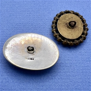 Two oval glass in metal buttons.