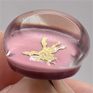 John Gooderham pink paperweight with gold foil horse and rider glass studio button.