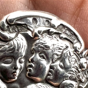 Hallmarked silver button of five cherub heads.