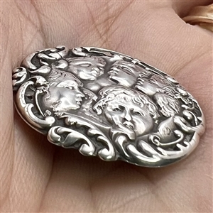 Hallmarked silver button of five cherub heads.
