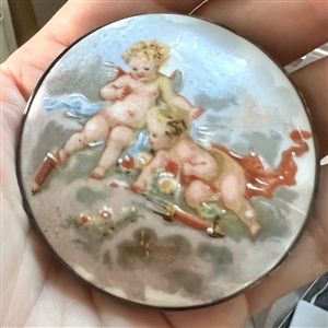 Ceramic button of two cherubs.