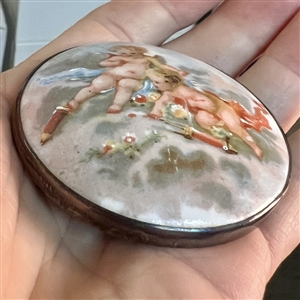 Ceramic button of two cherubs.