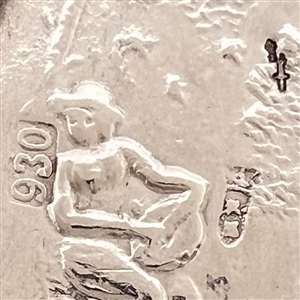 Hallmarked silver button of man playing an instrument in a garden.