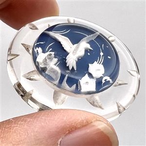 Reverse carved and painted acrylic button of a flying bird.