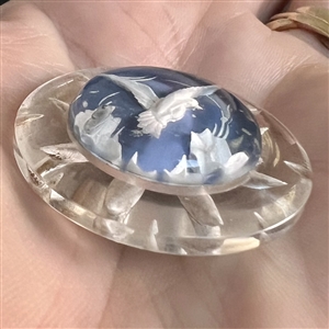 Reverse carved and painted acrylic button of a flying bird.