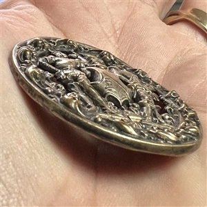 Brass button of two supporters and a shield and helm.