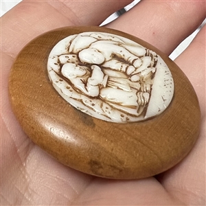 A 19th c. Wood button with a molded glass insert of Asian men.