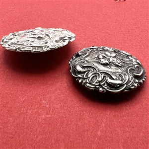 Two silver buttons of cherubs. 