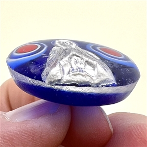 Glass studio paperweight button with sulphide by Theresa Rarig.