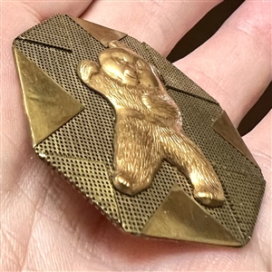 Handkerchief corner metal studio button of a bear by Phil Linley.