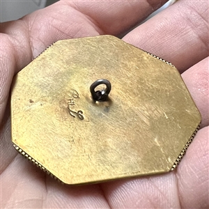 Handkerchief corner metal studio button of a bear by Phil Linley.