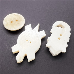 Three carved natural material buttons of animals.