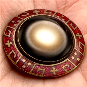 Glass in metal button with an unusual enamel border.