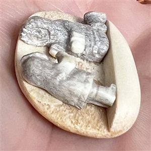 Scarce! Carved natural material studio button of an Eskimo adult and child.