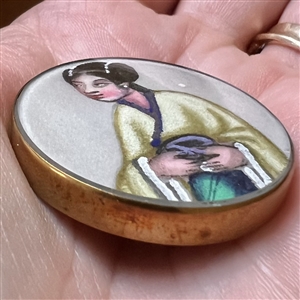 Painting on fabric button of an Asian woman.