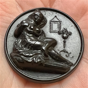 Gutta Percha (?) stud of draped partially nude woman. 