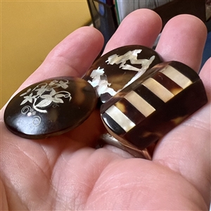 Three tortoise shell studs with inlay.
