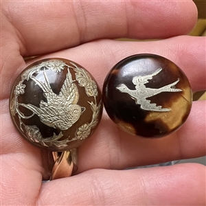 Two tortoise shell with inlay of birds, a stud and a button.
