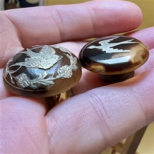 Two tortoise shell with inlay of birds, a stud and a button.