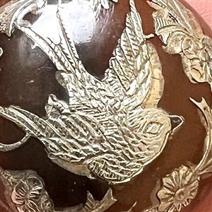 Two tortoise shell with inlay of birds, a stud and a button.