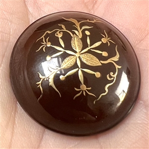 Painted gold plant life on lacquered domed button. 
