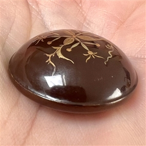 Painted gold plant life on lacquered domed button. 