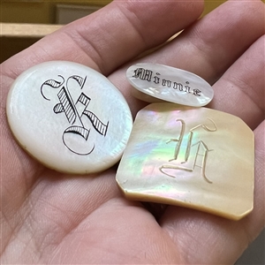Three pearl buttons with verbal.