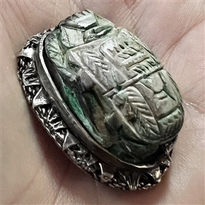 Ceramic button of an Egyptian scarab design set in metal.