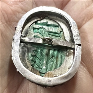 Ceramic button of an Egyptian scarab design set in metal.