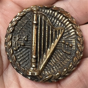 Metalized plastic Diamond D button of harp and music notes.