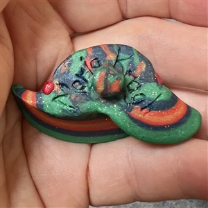 Sculpty clay studio button of a hat by Maria Kragh.