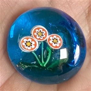 Glass paperweight studio button of flowers.